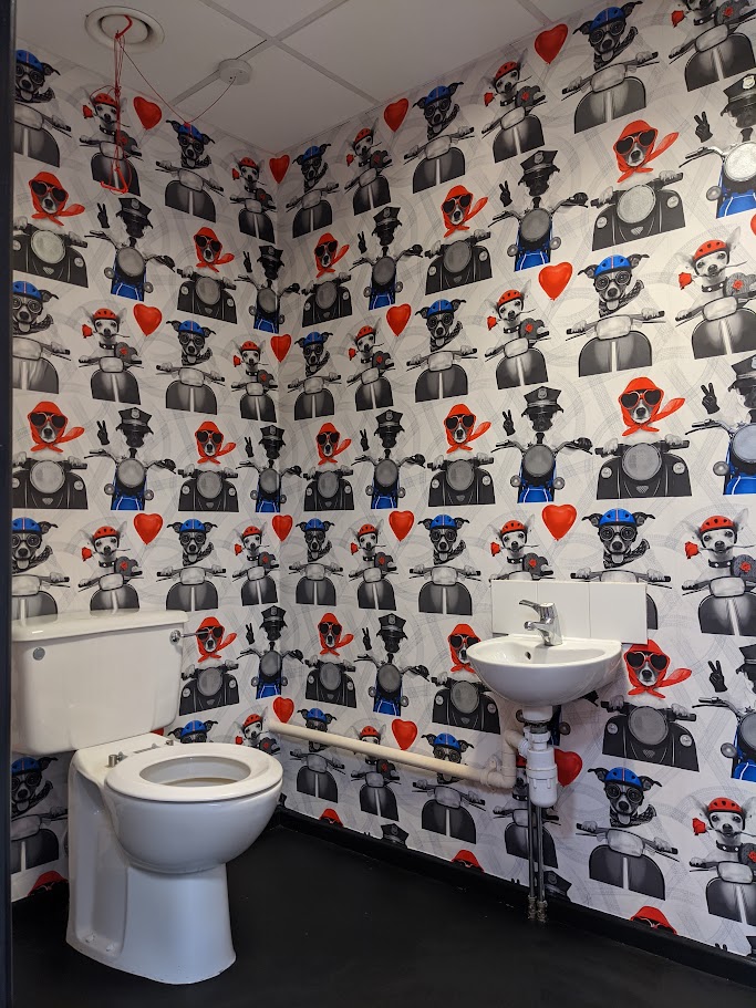 Commercial decorators hanging wallpaper in an accessible disabled WC in a Sheffield office