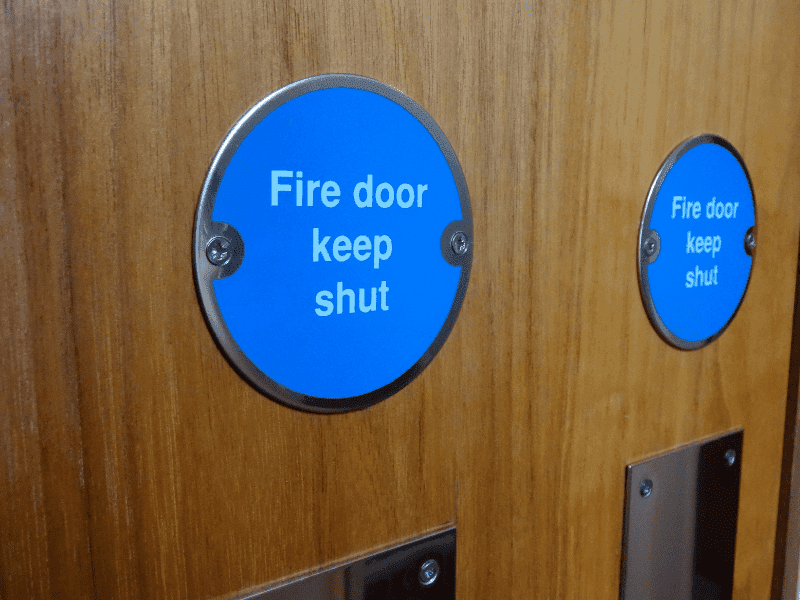 Fire door signage and compliance labelling in a commercial building