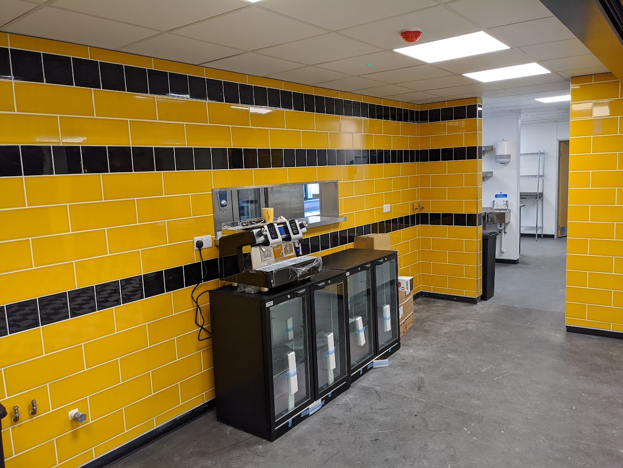 Installing tiled splashback in a commercial kitchen area