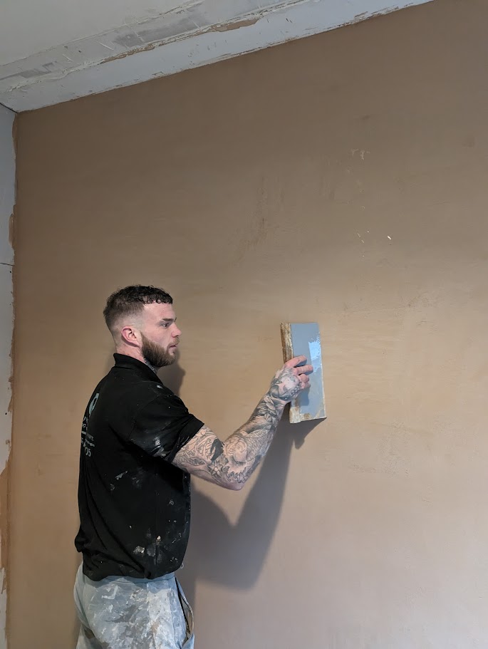 Commercial plasterer skimming a wall in a Sheffield premises